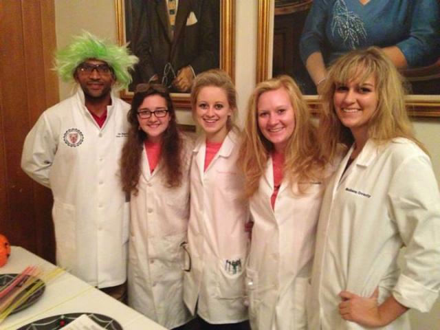 Professor Kayode Oshin, left, and students who are members of the Saint Mary’s Affiliates of the American Chemical Society (SMAACS) put on the show. Kate Bussey '15, president of SMAACS, is center left.